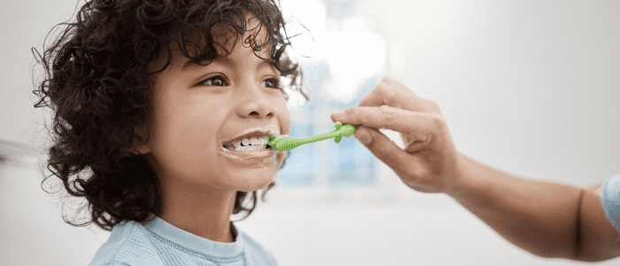 shot of father brushing his little sons teeth in a bathroom at home