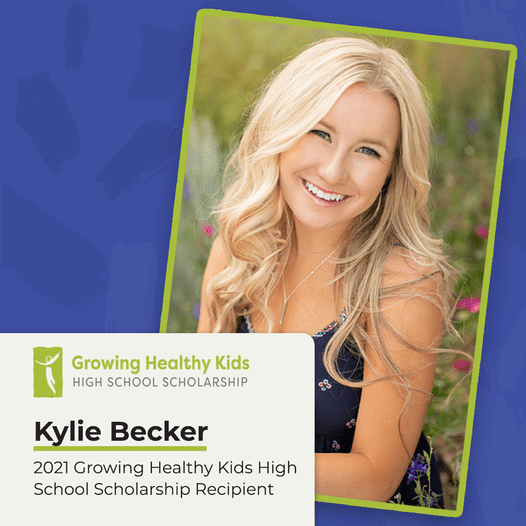 Smiling person with long blonde hair and a light dress sits outdoors on grass with purple flowers. Overlay text reads: "Growing Healthy Kids High School Scholarship. Kylie Becker, 2021 Growing Healthy Kids High School Scholarship Recipient.